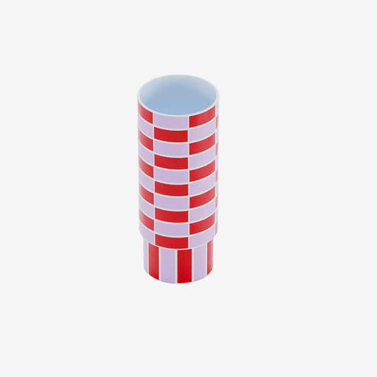 Le vase céramique tube à damier rouge et rose joue avec les motifs géométriques et la couleur : un plaisir pour se sentir bien chez soi dans un intérieur haut en couleurs